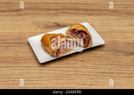 Venezuelan breakfast piece filled with ham and cheese on a white plate Stock Photo