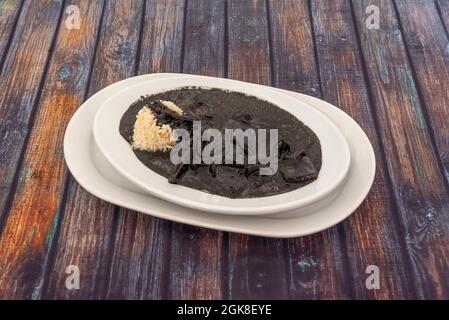 Tray of delicious Spanish recipe for squid stewed in its ink with white rice Stock Photo