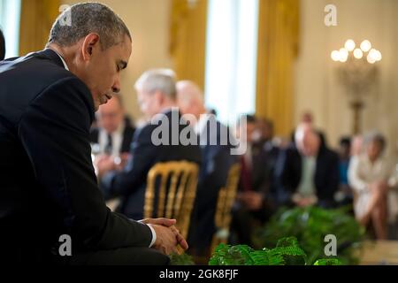 President Barack Obama bows his head during the closing prayer at the Easter Prayer Breakfast in the East Room of the White House, April 7, 2015. (Official White House Photo by Pete Souza) This official White House photograph is being made available only for publication by news organizations and/or for personal use printing by the subject(s) of the photograph. The photograph may not be manipulated in any way and may not be used in commercial or political materials, advertisements, emails, products, promotions that in any way suggests approval or endorsement of the President, the First Family, Stock Photo