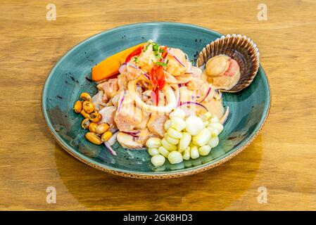 Sea bass and seafood ceviche with squid, corn grains of various types and pieces of sweet potatoes Stock Photo