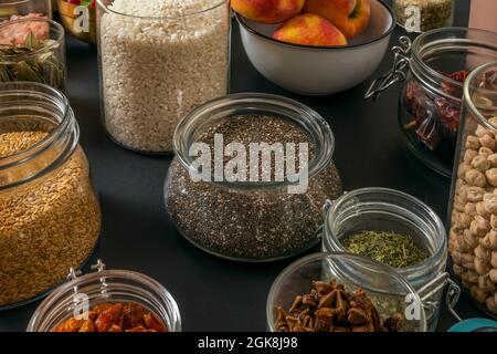 image of glass jars with haute cuisine ingredients ready for the elaboration of a large dish on a black background Stock Photo