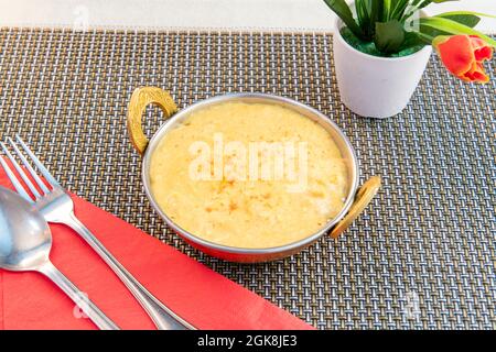 Chicken korma mild curry with lots of coconut served in a traditional Pakistani metal bowl Stock Photo