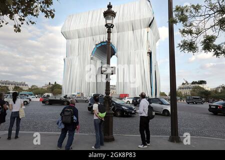 Paris, France. 13th Sep, 2021. People look at the Arc de Triomphe as it is being wrapped in silvery blue fabric in Paris, France, on Monday, September 30, 2021. The landmark is covered with 25,000 square meters of material, posthumously fulfilling a 60-year dream for the artist Christo. Photo by Eco Clement/UPI Credit: UPI/Alamy Live News Stock Photo