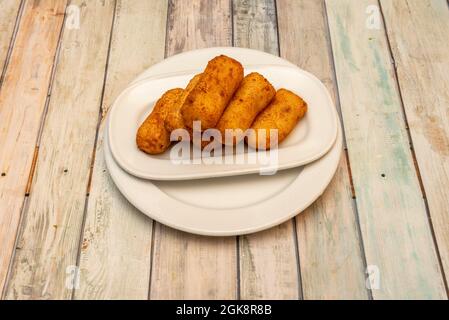 serving of cod croquettes typical of a Spanish tapas bar on white plates Stock Photo