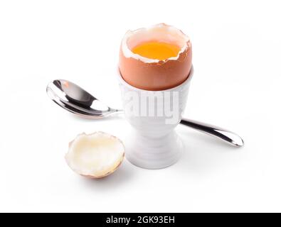 Soft boiled egg with egg cup and spoon isolated on white background, close-up. Stock Photo