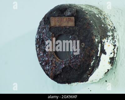 Close up shoot of rustic fire alarm that installed on  white wall Stock Photo
