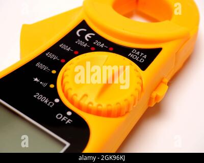Picture of yellow digital clamp meter that using for measuring electrical current, voltage and resistance. Shoot on white isolated background. Stock Photo