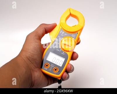 Picture of yellow digital clamp meter that using for measuring electrical current, voltage and resistance. Shoot on white isolated background. Stock Photo