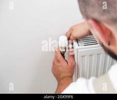 Plumber installing new steel hot water central heating radiator Stock Photo