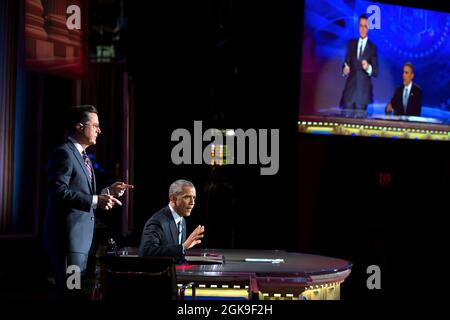 President Barack Obama takes over for Stephen Colbert during 'The Word' segment of 'The Colbert Report with Stephen Colbert' during a taping at George Washington University's Lisner Auditorium in Washington, D.C., Dec. 8, 2014. (Official White House Photo by Pete Souza) This official White House photograph is being made available only for publication by news organizations and/or for personal use printing by the subject(s) of the photograph. The photograph may not be manipulated in any way and may not be used in commercial or political materials, advertisements, emails, products, promotions tha Stock Photo