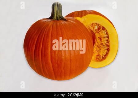 Whole pumpkin cut in half on white background. Stock Photo