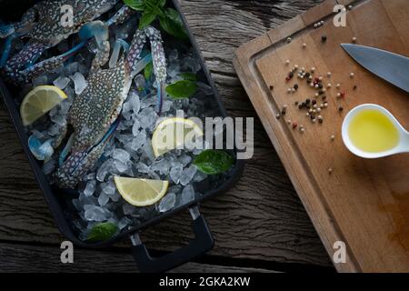 Seafood overhead shot. Fresh crab prawns on ice and wooden background. Stock Photo