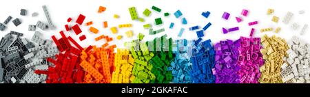 top view of wide pile various colorful rainbow colored stackable plastic toy bricks isolated on white panorama background.. childhood education constr Stock Photo