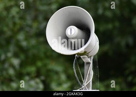 An old, retro style megaphone with the backdrop of a vegetation Stock Photo