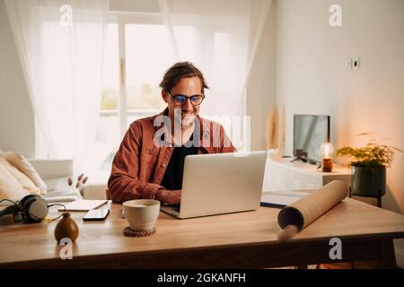 Caucasian male working from home typing on laptop finishing project Stock Photo