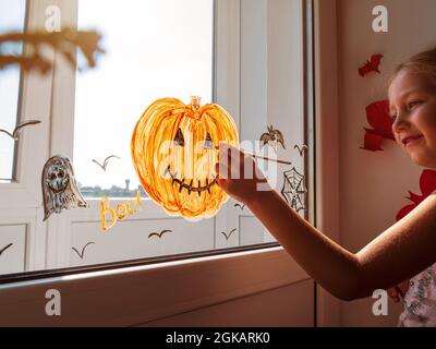 Preparing for Halloween. Teenage kid hands cutting black paper bat