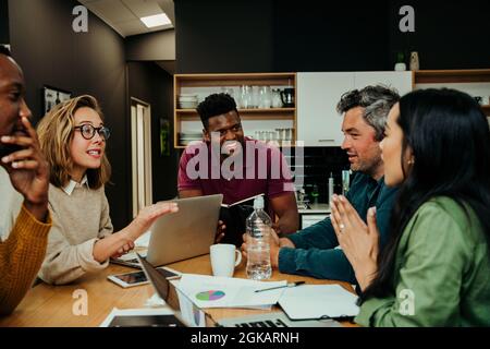 Team meeting during lunch break in office lounge briefing before big presentation with boss Stock Photo