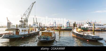 Historic boats and harbor cranes in the museum harbor in Hamburg Övelgönne in the morning sunlight Stock Photo