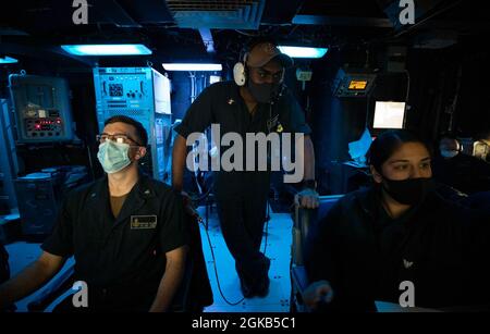 Sonar Technician (Surface) 1st Class Anthony Saucier supervises Sonar Technician (Surface) 3rd Class Rosa Angeles and Sonar Technician (Surface) 3rd Class Winston Allen as they stand watch in the sonar control room aboard the Arleigh Burke-class guided-missile destroyer USS John S. McCain (DDG 56) as part of an anti-submarine warfare exercise during the annual U.S.-Japan Bilateral Advanced Warfighting Training exercise. BAWT focuses on joint training and interoperability of coalition forces, and enables real-world proficiency and readiness in response to any contingency. Stock Photo