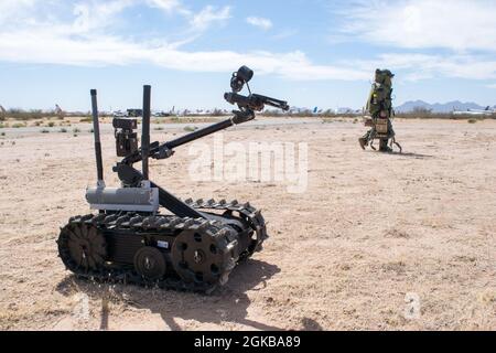 An Air Force Explosive Ordnance Disposal Technician with the 30th Civil Engineering Squadron of Vandenberg AFB, CA walks an AN/PLT-4 and AN/PLT-5, two IED Jammers, while using a TALON robot as an “extra set of eyes” to assess a problem during a training lane at Raven’s Challenge, an annual inter-agency, counter IED exercise that incorporates scenarios focused on interoperability capabilities between public safety bomb squads (PSBSs) and military explosive ordnance disposal (EOD) units in operational environments at Pinal Airpark, AZ 02 March 2021. Stock Photo