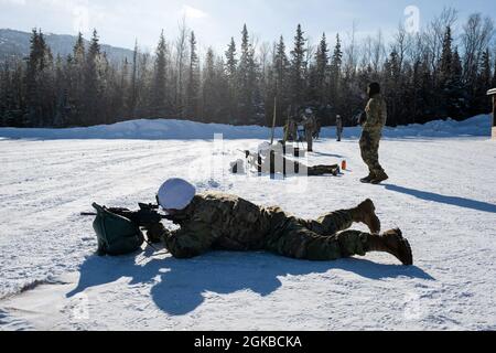 Army paratroopers with Comanche Company, 1st Battalion, 501st Parachute Infantry Regiment, 4th Infantry Brigade Combat Team (Airborne), 25th Infantry Division, U.S. Army Alaska, fire their M4 carbines during live-fire training at Joint Base Elmendorf-Richardson, Alaska, March 3, 2021. The Soldiers practiced identifying, and engaging targets at varying distances to solidify their weapon proficiency in winter conditions. Stock Photo