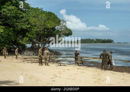 U.S. Marines and Sailors with the 31st Marine Expeditionary Unit (MEU) clean trash off a beach on the Island of Peleliu, Republic of Palau, March 3, 2021. The 31st MEU is operating aboard ships of the Amphibious Squadron 11 in the 7th fleet area of operations to enhance interoperability with allies and partners and serve as a ready response force to defend peace and stability in the Indo-Pacific region. Stock Photo