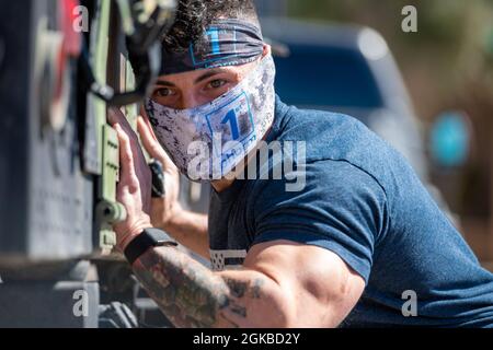 Staff Sgt. Vincent Cavazos, 56th Security Forces Squadron base defense operations control center controller, pushes a Humvee during a strongman competition, March 3, 2021, at Luke Air Force Base, Arizona. Participants had to push the vehicle  25 feet to successfully complete the challenge. Fitness events boost morale and contribute to a fit-to-fight Air Force. Stock Photo