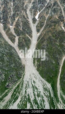 The texture of the mountain. The relief of a mountain slope with snow. Abstract natural background.Vertical photo Stock Photo