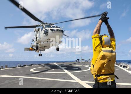 Boatswain’s Mate 2nd Class Dane Potzinger, from Ada, Mich., signals a Japan Maritime Self Defense Force SH-60 Seahawk to lift off of the flight deck of the Arleigh Burke-class guided-missile destroyer USS Benfold (DDG 65) during the annual U.S.-Japan Bilateral Advanced Warfighting Training Exercise. BAWT focuses on joint training and interoperability of coalition forces, and enables real-world proficiency and readiness in response to any contingency. Stock Photo