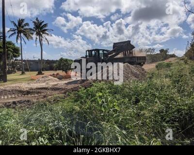 210304-N-WS023-1162 TINIAN, Commonwealth of the Northern Mariana Islands (March 4, 2021) Seabees assigned to Naval Mobile Construction Battalion (NMCB) 4, clear and excavate material to lay a foundation for road upgrades as part of the Marpo Heights Innovative Readiness Training road repair project prior to road paving. The road project will bring unimproved roads up to Department of Transportation standards in the Marpo Heights area. NMCB-4 is forward deployed throughout the Indo-Pacific region and United States ready to support major combat operations, theater security, humanitarian assistan Stock Photo