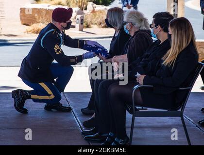 Sgt. 1st Class Micheal Stroud, a platoon sergeant assigned to D Company, 2nd Battalion, 325th Airborne Infantry Regiment, 2nd Brigade Combat Team, 82nd Airborne Division, presents the U.S. Flag to Marlene Ritts, the daughter of recently deceased Pfc. Harvey Brown, during a funeral service at Fort Bliss National Cemetery on Fort Bliss, Texas, March 5, 2021. Pfc. Brown served in World War II with 2nd Battalion, 505th Parachute Infantry Regiment, 82nd Abn. Div. and fought in Italy, France, The Netherlands and Belgium. Stock Photo