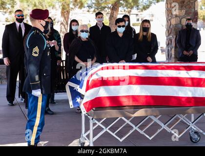 Sgt. 1st Class Michael Stroud, a platoon sergeant assigned to D Company, 2nd Battalion, 325th Airborne Infantry Regiment, 2nd Brigade Combat Team, 82nd Airborne Division, and the family of Pfc. Harvey Brown, a World War II veteran formerly assigned to 2nd Battalion, 505th Parachute Infantry Regiment, stand in silence during a funeral at Fort Bliss National Cemetery on Fort Bliss, Texas, March 5, 2021. Pfc. Brown was one of less than 3,000 Paratroopers to make all four combat jumps during World War II and fought in Italy, France, The Netherlands and Belgium. Stock Photo