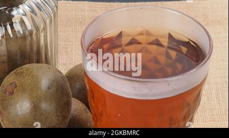 Monk fruit or Luo Han Guo. Dried fruits for healthy sweetener drink. Natural herbal remedy and glass bottle background. Monk fruit drink for who conce Stock Photo