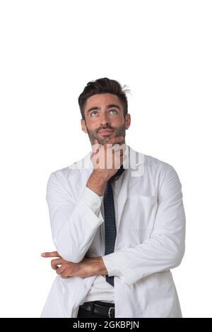 Young doctor surgeon man over isolated white background with hand on chin thinking about question, pensive expression. Doubt concept. Stock Photo