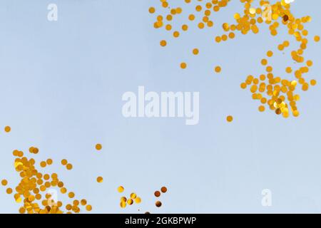 Light blue background with golden confetti, selective focus Stock Photo