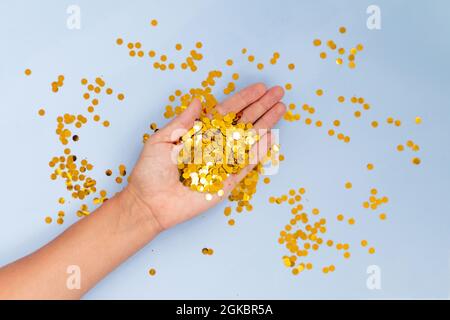 Light blue background with golden confetti, selective focus Stock Photo