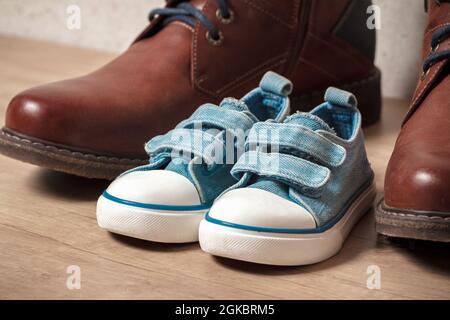 Men's and children's shoes on a wooden floo Stock Photo