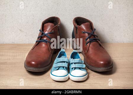 Men's and children's shoes on a wooden floo Stock Photo
