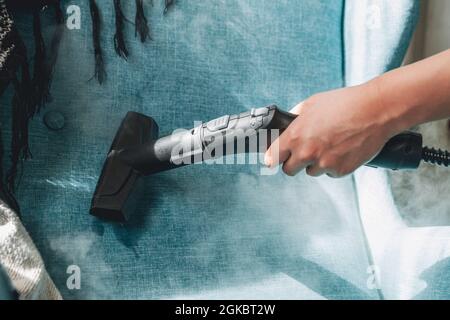 Hand cleaning a armchair with steam cleaner, Home cleaning conce Stock Photo