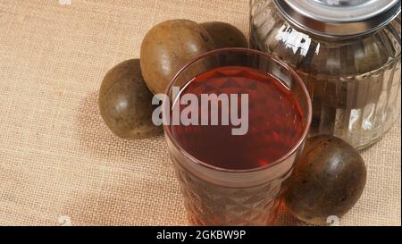 Monk fruit or Luo Han Guo. Dried fruits for healthy sweetener drink. Natural herbal remedy and glass bottle background. Monk fruit drink for who conce Stock Photo