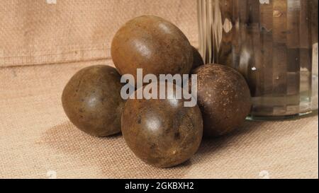 Monk fruit or Luo Han Guo. Dried fruits for healthy sweetener drink. Natural herbal remedy and glass bottle background. Monk fruit drink for who conce Stock Photo