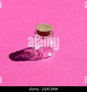 Empty little bottles with cork stopper on pink background front view Stock Photo
