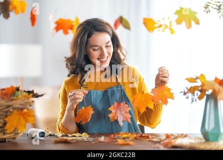 Happy woman doing autumn decor. Fall atmosphere Stock Photo
