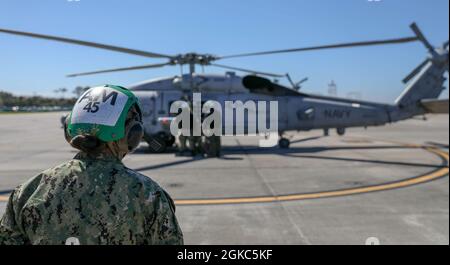 210309-N-KY668-1067 NAVAL STATION MAYPORT, Fla. (March 9, 2021) Aviation Structural Mechanic 2nd Class Kimberly Espinoza oversees maintenance being performed on an MH-60R Seahawk helicopter assigned to the “Airwolves” of Helicopter Maritime Strike Squadron (HSM) 40 on Naval Station Mayport, Fla. HSM-40 operates as one of two MH-60R Fleet Replacement Squadrons that provide Helicopter Maritime Strike Wing Atlantic with training and support. Stock Photo