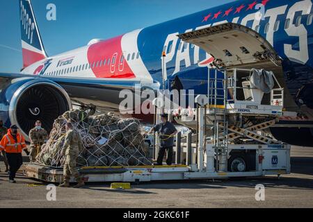 Airmen from the 103rd Logistics Readiness Squadron assist civilian crews loading cargo onto a Boeing 767-300ER at Bradley Air National Guard Base in East Granby, Connecticut, March 10, 2021. The “AirKraft” transported more than 100 deploying Soldiers from the Connecticut National Guard’s 1-102nd Infantry Regiment who will be supporting Operation Enduring Freedom’s Horn of Africa mission. Stock Photo