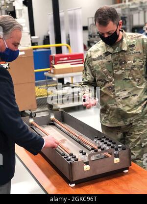 Chemical Materials Activity (CMA) Deputy Director Laurence G. Gottschalk, left, shows Col. Gavin J. Gardner, Commander of the Joint Munitions Command and Joint Munitions and Lethality Life Cycle Management Command, the CAIS bottle holder for the Explosive Destruction System (EDS). This innovation, developed through CMA’s Research, Development, Test and Evaluation program, enables the U.S. Army to destroy up to 178 chemical-agent filled bottles in a single EDS operation, resulting in significant cost and waste reduction. Stock Photo