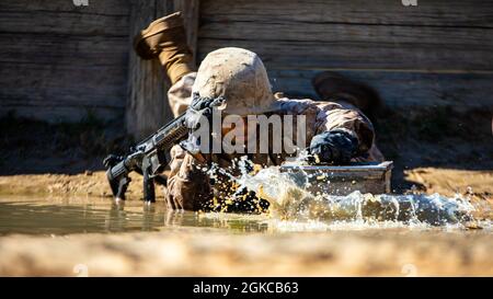 A recruit assigned to Papa Company, 4th Recruit Training Battalion, low crawls during the Crucible on Marine Corps Recruit Depot Parris Island, South Carolina, March 11, 2021. The Crucible is a culminating event that tests recruits mentally and physically and is the final step before becoming a U.S. Marine. Stock Photo