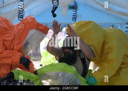 Members from the 51st Civil Engineer Squadron and the 51st Aerospace Medicine Squadron go through a hot wash at Osan Air Base, Republic of Korea, March 11, 2021. The wash was part of a routine training event involving a suspicious package call. Stock Photo