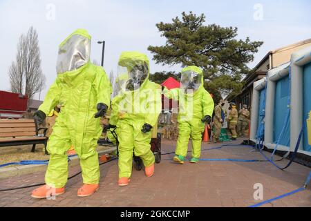 Members from the 51st Civil Engineer Squadron and the 51st Aerospace Medicine Squadron walk up in Level-A Suits at Osan Air Base, Republic of Korea, March 11, 2021. They wore these suits to investigate a suspicious package call for a routine training. Stock Photo