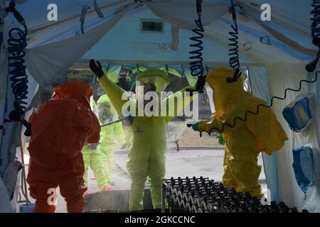 Members from the 51st Civil Engineer Squadron and the 51st Aerospace Medicine Squadron go through a hot wash at Osan Air Base, Republic of Korea, March 11, 2021. The wash was part of a routine training event involving a suspicious package call. Stock Photo